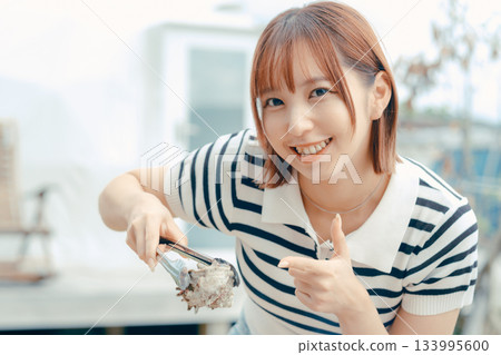 一位二十多歲的女子在海灘上烤海鮮 一位二十多歲的女子在海灘上烤海鮮 133995600