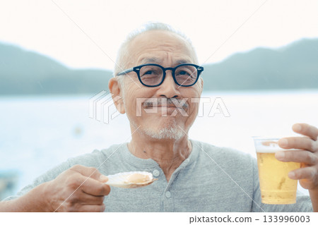 老人們在海灘上享用啤酒和貝類菜餚 老人們在海灘上享用啤酒和貝類菜餚 133996003