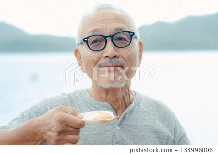 老人們在海灘上享用啤酒和貝類菜餚 133996006