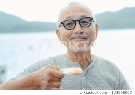 老人們在海灘上享用啤酒和貝類菜餚 老人們在海灘上享用啤酒和貝類菜餚 133996007
