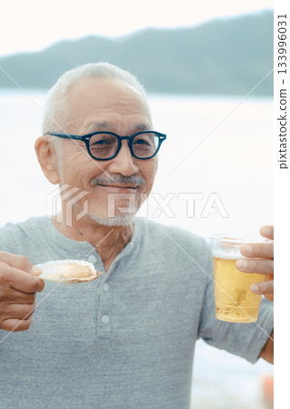 A scene of a senior man enjoying beer and shellfish dishes at the beach 133996031