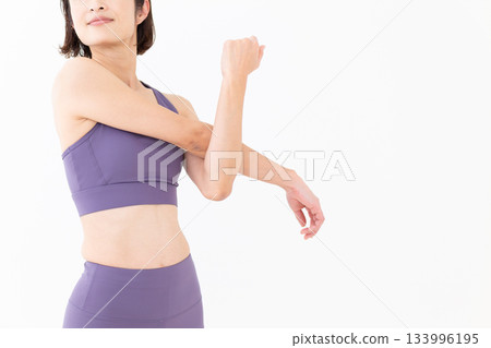 Middle-aged woman in yoga wear doing stretching exercises 133996195