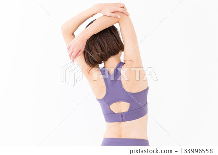 Middle-aged woman in yoga wear doing stretching exercises Middle-aged woman in yoga wear doing stretching exercises 133996558