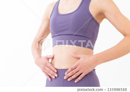 Slim belly of a middle-aged woman in yoga wear Slim belly of a middle-aged woman in yoga wear 133996588