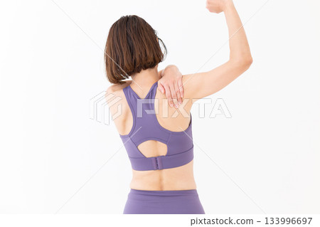 Middle-aged woman in yoga wear doing stretching exercises Middle-aged woman in yoga wear doing stretching exercises 133996697