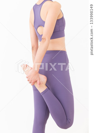 Middle-aged woman in yoga wear doing stretching exercises 133998149