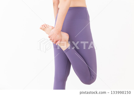Middle-aged woman in yoga wear doing stretching exercises Middle-aged woman in yoga wear doing stretching exercises 133998150