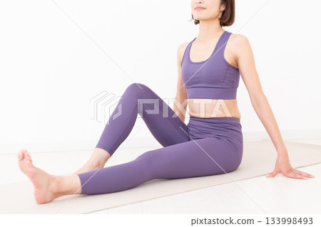 Middle-aged woman in yoga wear doing stretching exercises Middle-aged woman in yoga wear doing stretching exercises 133998493