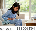 一個女孩因胃痛摀著肚子。 133998594