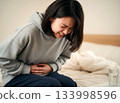 一個女孩因胃痛摀著肚子。 133998596