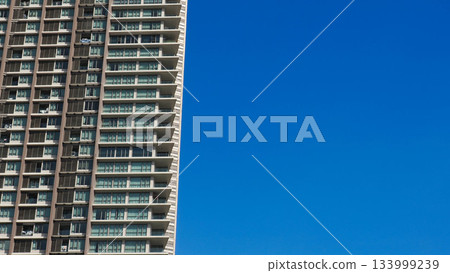 Modern Residential High-Rise Building Facade against Clear Blue Sky with Copy Space Modern Residential High-Rise Building Facade against Clear Blue Sky with Copy Space 133999239