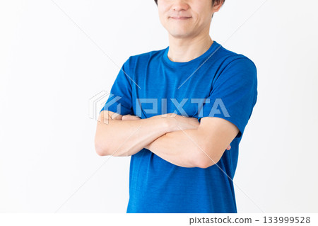 A middle-aged man wearing a T-shirt and crossing his arms A middle-aged man wearing a T-shirt and crossing his arms 133999528