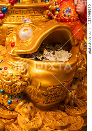 Golden frog statue filled with money at a temple Golden frog statue filled with money at a temple 133999980
