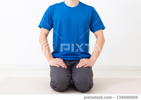 A middle-aged man in a T-shirt sitting in seiza position A middle-aged man in a T-shirt sitting in seiza position 134000009