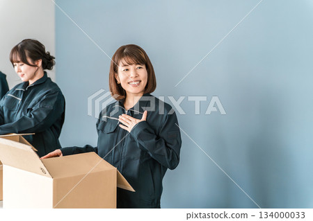 Male and female transportation, logistics, courier, distribution, delivery, and delivery workers packing items into cardboard boxes 134000033