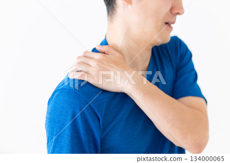 A middle-aged man wearing a T-shirt suffering from stiff shoulders 134000065