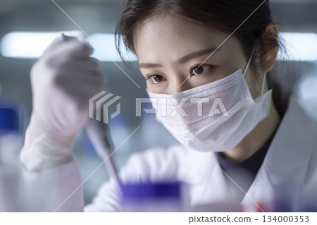 A Japanese female researcher wearing a mask and concentrating on an experiment 134000353