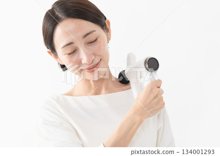 Woman using a massage machine Lifestyle image 134001293