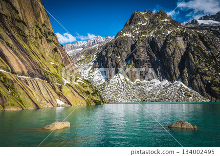 Gelmersee lake and snowy mountains in background, Grimsel Pass, Switzerland 134002495