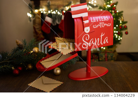Santa Mailbox Scene. Festive red mailbox for Santa letters surrounded by Christmas decor. 134004229