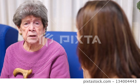 Elderly grandmother talking with granddaughter in nursing home Elderly grandmother talking with granddaughter in nursing home 134004443