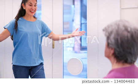 Granddaughter visiting grandmother bringing happy surprise to nursing home Granddaughter visiting grandmother bringing happy surprise to nursing home 134004483