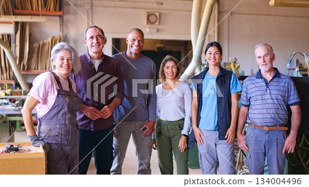 Diverse team of smiling factory workers standing in workshop 134004496