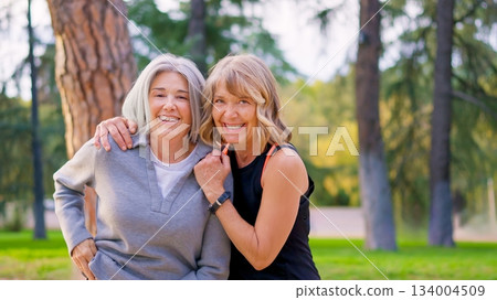 Playful senior friends smiling together outdoors Playful senior friends smiling together outdoors 134004509