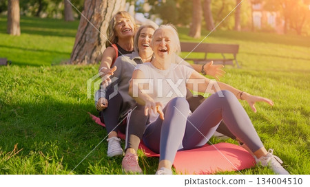 Happy senior women friends exercising together in park Happy senior women friends exercising together in park 134004510