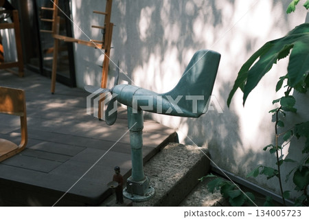 A retro airplane-shaped weather vane with beautiful sunlight filtering through the trees A retro airplane-shaped weather vane with beautiful sunlight filtering through the trees 134005723