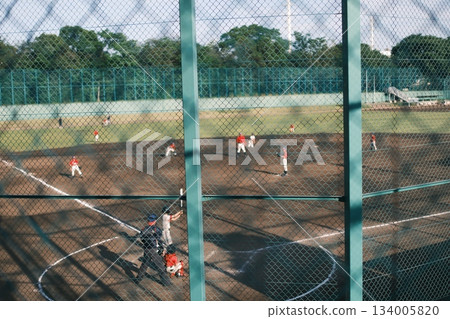 A view of the dirt field and a baseball game from my youth through a wire fence A view of the dirt field and a baseball game from my youth through a wire fence 134005820