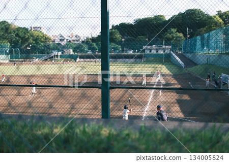 Summer baseball field, youth baseball through the fence Summer baseball field, youth baseball through the fence 134005824
