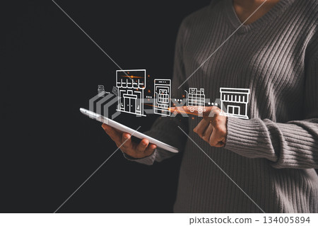 A woman using a digital tablet with virtual storefront, mobile app and logistics icons, illustrating online retail management, ecommerce workflow and modern digital business operations. A woman using a digital tablet with virtual storefront, mobile app and logistics icons, illustrating online retail management, ecommerce workflow and modern digital business operations. 134005894