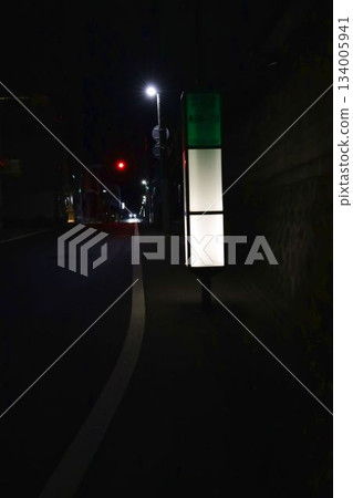 Residential area at night in winter. Bus stop, slope, houses, lights at night Residential area at night in winter. Bus stop, slope, houses, lights at night 134005941