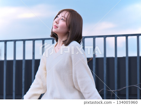 woman looking outside on balcony 134005960