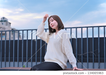 woman looking outside on balcony 134005963