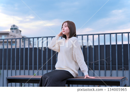 woman looking outside on balcony 134005965