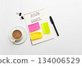 Minimal workspace with notebook, colorful sticky notes, pen, binder clips and coffee cup on white background, top view 134006529