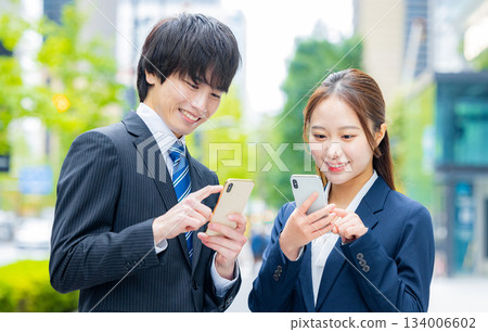 Businessman and businesswoman using smartphone 134006602