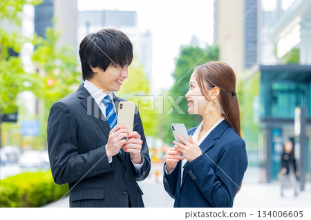 Businessman and businesswoman using smartphone Businessman and businesswoman using smartphone 134006605