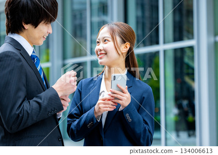Businessman and businesswoman using smartphone Businessman and businesswoman using smartphone 134006613