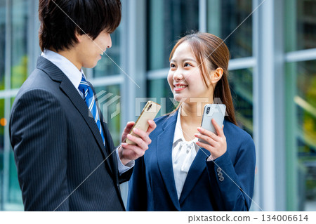 Businessman and businesswoman using smartphone Businessman and businesswoman using smartphone 134006614