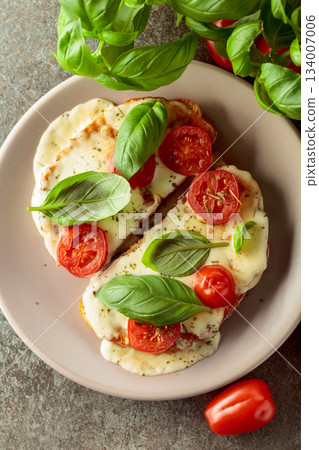 Hot open sandwiches with mozzarella, tomatoes and basil. 134007006