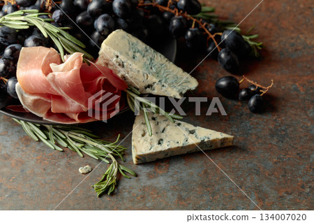 Prosciutto with blue cheese, grapes, and rosemary. Prosciutto with blue cheese, grapes, and rosemary. 134007020