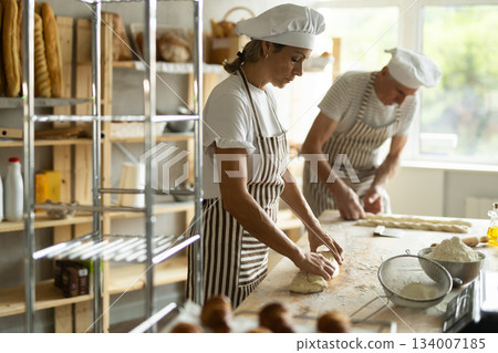Elderly man and woman kneading and braiding dough Elderly man and woman kneading and braiding dough 134007185