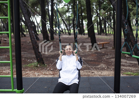 young pretty brunette woman outside making sport exercises on training playground, lifestyle people concept young pretty brunette woman outside making sport exercises on training playground, lifestyle people concept 134007269