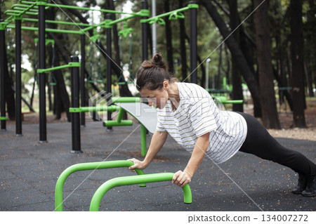 young pretty brunette woman outside making sport exercises on training playground, lifestyle people concept young pretty brunette woman outside making sport exercises on training playground, lifestyle people concept 134007272
