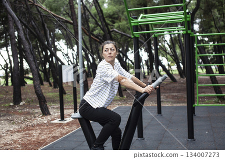 young pretty brunette woman outside making sport exercises on training playground, lifestyle people concept young pretty brunette woman outside making sport exercises on training playground, lifestyle people concept 134007273