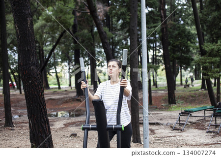 young pretty brunette woman outside making sport exercises on training playground, lifestyle people concept young pretty brunette woman outside making sport exercises on training playground, lifestyle people concept 134007274