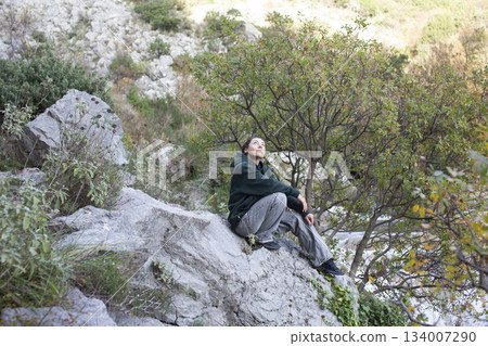 young pretty brunette girl hiking to waterfall, lifestyle people concept 134007290